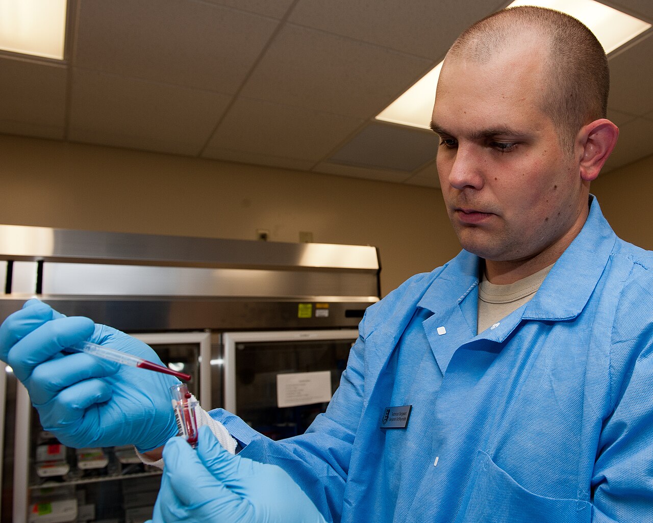 Laboratory technician handling a blood sample before chemistry analysis